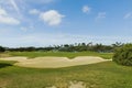 Beautiful view of process of automatic golf field and green trees on blue sky background. Tropical natural landscape backgrounds. Royalty Free Stock Photo