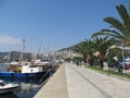 Beautiful view of the promenade of Kavala, where tourists and townspeople walk, surrounded by palm trees and parked pleasure boats