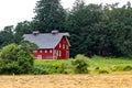 Beautiful view of a red barn surrounded by a lush forest Royalty Free Stock Photo