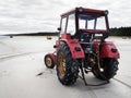 Beautiful view of a red tractor on a sandy beach Royalty Free Stock Photo