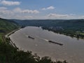 Beautiful view of Rhine river, an important inland shipping waterway, with two vessels passing by and vineyards.