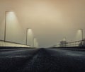 Beautiful view of a road on a foggy bridge with light poles Royalty Free Stock Photo