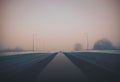 Beautiful view of a road on a foggy bridge with light poles Royalty Free Stock Photo