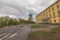 Beautiful view of roadway with crosswalk sign against backdrop of urban landscape with grey sky background. Sweden.