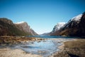 Beautiful view of rocky sea shore and beautiful mountains with snow peaks. Stony river bank Royalty Free Stock Photo