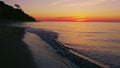 Beautiful view of rocky seashore against bright orange sunset in evening. Royalty Free Stock Photo