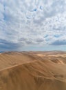 Beautiful view of sand dunes in the desert against a backdrop of a blue sky with white clouds Royalty Free Stock Photo