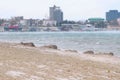 Beautiful view of the sand and snow storm on the beach with coastal town on background. Royalty Free Stock Photo