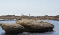 A beautiful view of the sea bay with large stones in the foreground, fishermen in the background. Campello, Spain