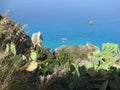 Rocky cliffs above the sky-blue sea Royalty Free Stock Photo