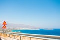 Beautiful view of the sea from the car window. Road Signs and fences on the road. Royalty Free Stock Photo