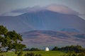 Beautiful view of a small house in the middle of a field and mountains in a background Royalty Free Stock Photo