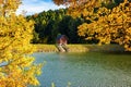 Beautiful view of small wooden house on bank of lake near forest during autumn Royalty Free Stock Photo