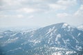 A beautiful view of the snow-capped mountains of the Carpathians from the top of Goverly in spring in a beautiful sunny day with l