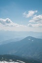 A beautiful view of the snow-capped mountains of the Carpathians from the top of Goverly in spring in a beautiful sunny