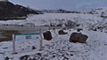 View of Solheimajokull, an outlet glacier of MÃÂ½rdalsjÃÂ¶kull, from viewpoint with information sign on cloudy day in winter.