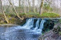 Beautiful view in spring of a waterfall in a small river Royalty Free Stock Photo