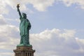 Beautiful view of Statue of Liberty on Liberty island in New York against on blue sky with white clouds background. Royalty Free Stock Photo