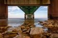 Beautiful view of stones in the water under the pier during sunrise Royalty Free Stock Photo