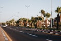 Beautiful view of the street in Egypt with a palm tree alley. Transport street with asphalt road. Sunny summer day with blue sky Royalty Free Stock Photo