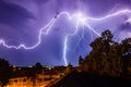 Beautiful view of a summer lightning over houses in the night sky. Royalty Free Stock Photo