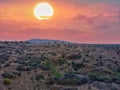 Beautiful view of sunset with red moody clouds and a barren land. Sunsetting, sunshine, clouds, moody clouds, barren land, sky