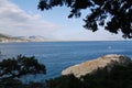 A beautiful view of the surface of the sea bay with a man on a catamaran floating near the shore and the coastline below