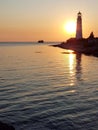 Beautiful view of the Tarkhankut lighthouse, the Black sea, the setting yellow sun on a cloudless summer day. Republic Of Crimea