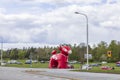 Beautiful view of temporary outdoor parking place for event. Huge inflated plastic ARLA red cow figure. Sweden.