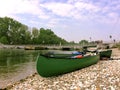 Green canoe waiting to enter the river during springtime