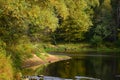 Beautiful view to the calm lake surrounded by lush green trees reflecting in water Royalty Free Stock Photo