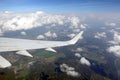 View to the earth from passenger supersonic airplane window flying high in the sky above white clouds