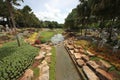 A beautiful view to a meadow with pond and grass and trees and stones in the Nong Nooch tropical botanic garden near Pattaya city