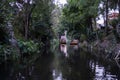 Traditional colorful trajinera surrounded by trees in Xochimilco lake