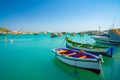 Beautiful view on the traditional eyed colorful boats Luzzu in the Harbor of Mediterranean fishing village Marsaxlokk, Malta Royalty Free Stock Photo