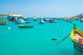 Beautiful view on the traditional eyed colorful boats Luzzu in the Harbor of Mediterranean fishing village Marsaxlokk, Malta Royalty Free Stock Photo