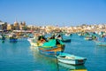 Beautiful view on the traditional eyed colorful boats Luzzu in the Harbor of Mediterranean fishing village Marsaxlokk, Malta Royalty Free Stock Photo