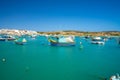 Beautiful view on the traditional eyed colorful boats Luzzu in the Harbor of Mediterranean fishing village Marsaxlokk, Malta Royalty Free Stock Photo