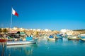 Beautiful view on the traditional eyed colorful boats Luzzu in the Harbor of Mediterranean fishing village Marsaxlokk, Malta Royalty Free Stock Photo