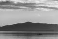 Beautiful view of Trasimeno lake at sunset with birds on water, a man on a canoe and hills on the background Royalty Free Stock Photo