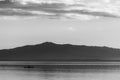 Beautiful view of Trasimeno lake at sunset with birds on water, a man on a canoe and hills on the background Royalty Free Stock Photo