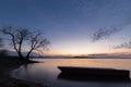 Beautiful view of Trasimeno lake Umbria at dusk, with a little boat silhouette in the foreground, perfectly still Royalty Free Stock Photo