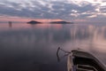 Beautiful view of Trasimeno lake Umbria at dusk, with a little, old boat partially filled by water, perfectly still