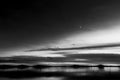 Beautiful view of Trasimeno lake Umbria, Italy at dusk, with black and white tones and moon in the sky Royalty Free Stock Photo