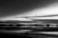 Beautiful view of Trasimeno lake Umbria, Italy at dusk, with black and white tones and moon in the sky Royalty Free Stock Photo