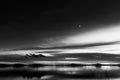 Beautiful view of Trasimeno lake Umbria, Italy at dusk, with black and white tones and moon in the sky Royalty Free Stock Photo