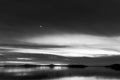 Beautiful view of Trasimeno lake Umbria, Italy at dusk, with black and white tones and moon in the sky Royalty Free Stock Photo