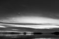 Beautiful view of Trasimeno lake Umbria, Italy at dusk, with black and white tones and moon in the sky Royalty Free Stock Photo