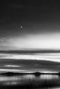 Beautiful view of Trasimeno lake Umbria, Italy at dusk, with black and white tones and moon in the sky Royalty Free Stock Photo