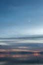 Beautiful view of Trasimeno lake Umbria, Italy at dusk, with blue and orange tones and moon in the sky Royalty Free Stock Photo